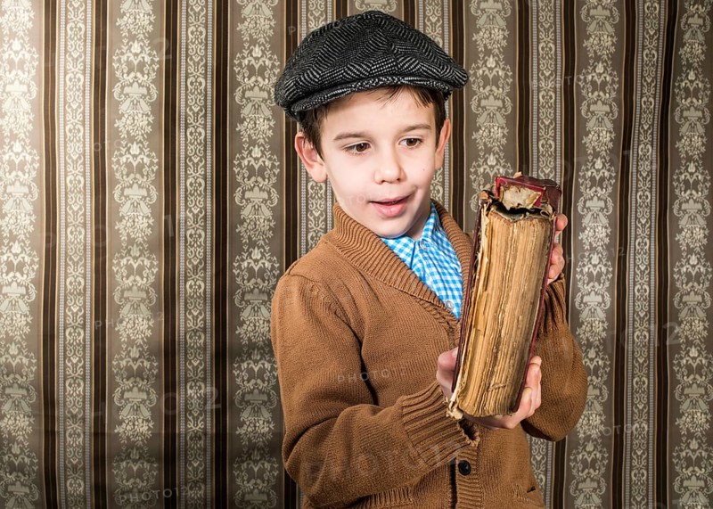 Child with red vintage book. Vintage clothes and hat