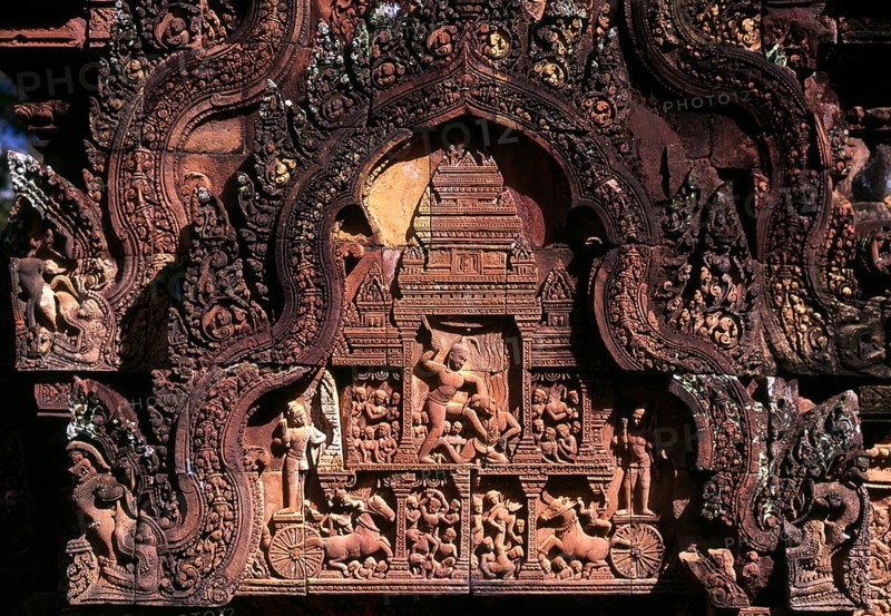 Banteay Srei (or Banteay Srey) is a 10th century Cambodian temple dedicated to the Hindu god Shiva and is located to the north-east of the main group of temples at Angkor. Banteay Srei is built largely of red sandstone, a medium that lends itself to the elaborate decorative wall carvings which are still observable today. Banteay Srei is sometimes referred to as the jewel of Khmer art
