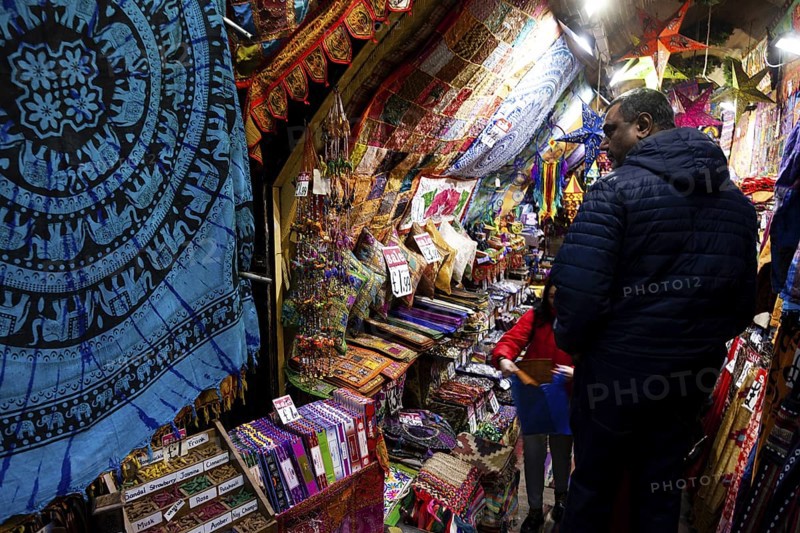 A vibrant market stall showcasing colorful textiles and tapestries in the London Borough of Camden, Greater London, United Kingdom
