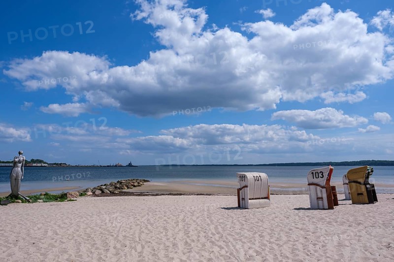 A quiet beach with beach chairs and a sculpture at the water's edge, Eckernförde, Schleswig-Holstein, Germany