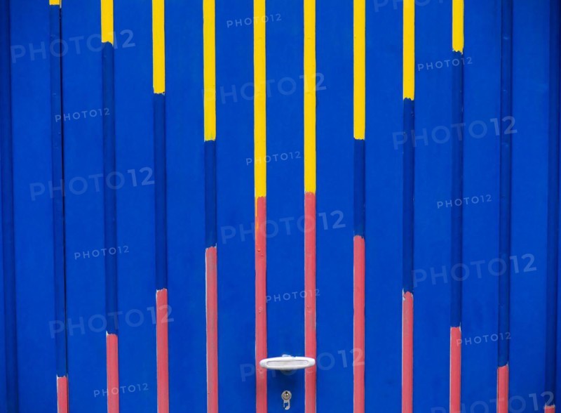 Garage door with graphic pattern in the colours blue, red and yellow, format-filling