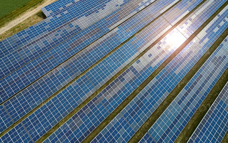 Solar panel field at work with sun reflection