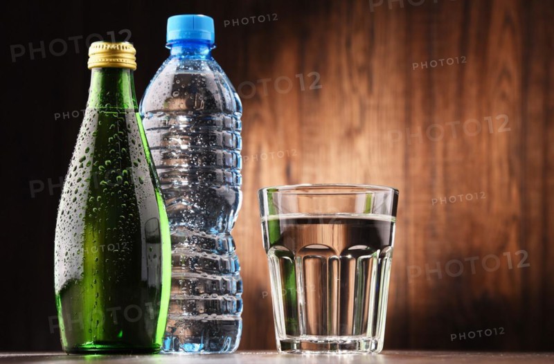Composition with glass and bottles of mineral water