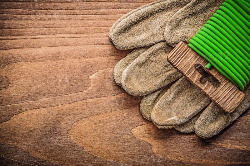 Garden tie wire leather safety gloves on wooden board gardening concept