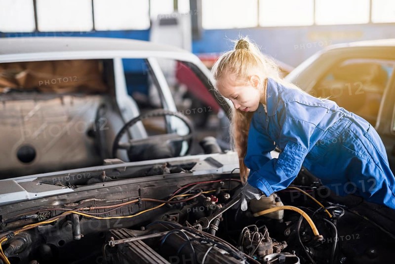 Little girl repairing car with spanner