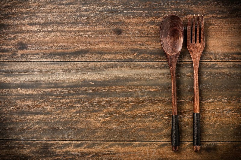 Wooden spoon and fork on rustic wooden table with copy space for your text