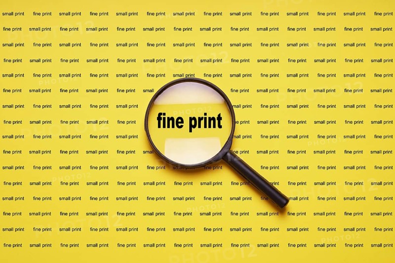fine print enlarged with magnifying glass magnifier loupe, business concept