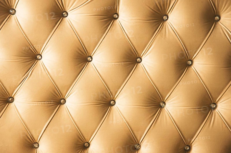 Beige soft textile background with symmetrical buttons on the corners of diamonds. Soft and expensive furniture elements. Luxury background