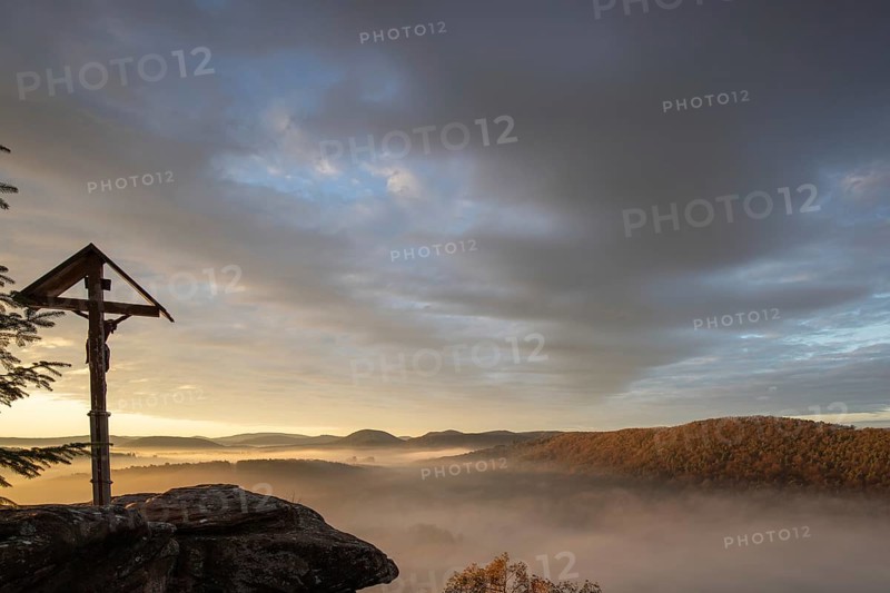 Mystical sunrise at the Wachtfelsen. Fascinating landscape shot between fog and clouds near Wernersberg, Pfälzerwald, Germany