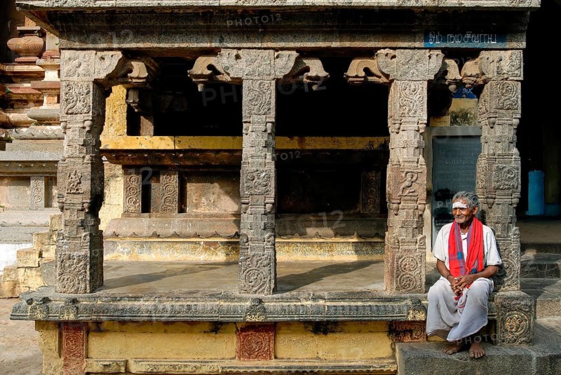 Old man sitting in front of Kandarathithan Gopuram in Virudhagireeswarar Shiva temple in Virudhachalam, Tamil Nadu, South India, India, Asia