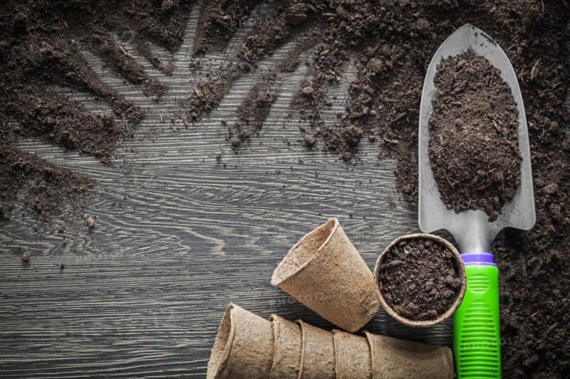 Peat pots soil shovel on wooden board