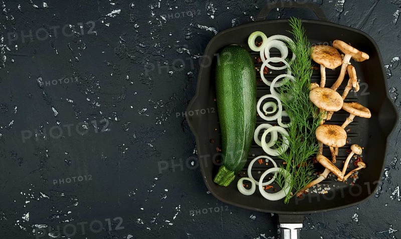 Fresh mushrooms with spices and herbs on black board. View from above. Copy space