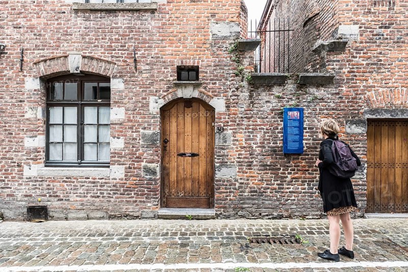 Tournai Doornik, Walloon Region, Belgium, 08 14 2019 Local tourist in summer dress looking at the facade and entrance of the Folklore museum