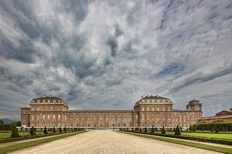 Impressive view of a large baroque palace with clouds in the sky, Palace of Venaria Reale, Residences of the House of Savoy, Turin, Piedmont, Italy