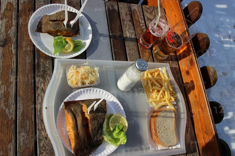 Eating fried fish outside, winter at the Baltic Sea