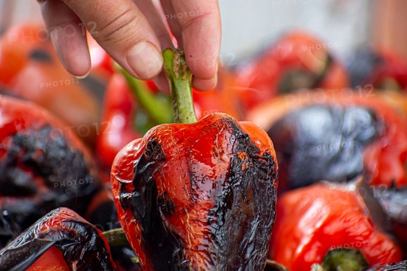 Red peppers roasting on a wood-fired stove in preparation for making ajvar, a traditional serbian dish
