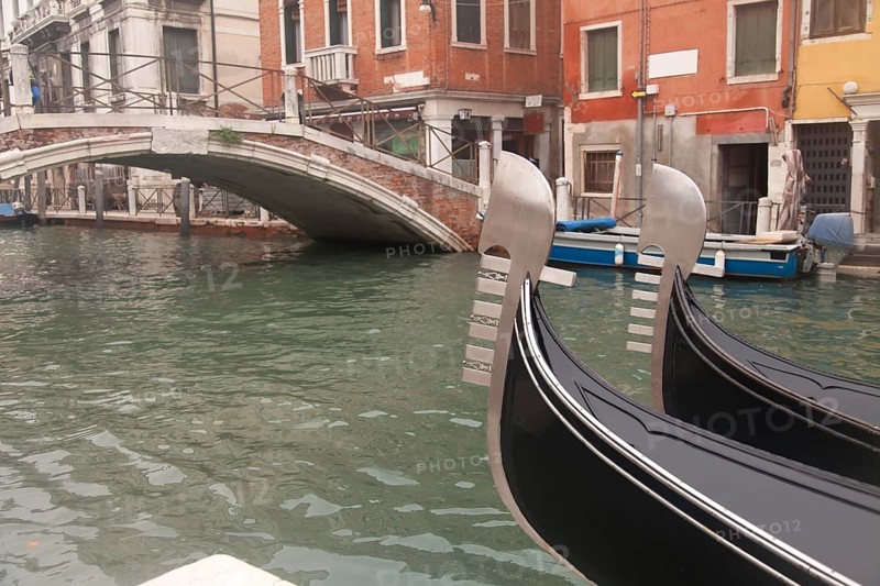 Two gondola in Venice near pier and bridge