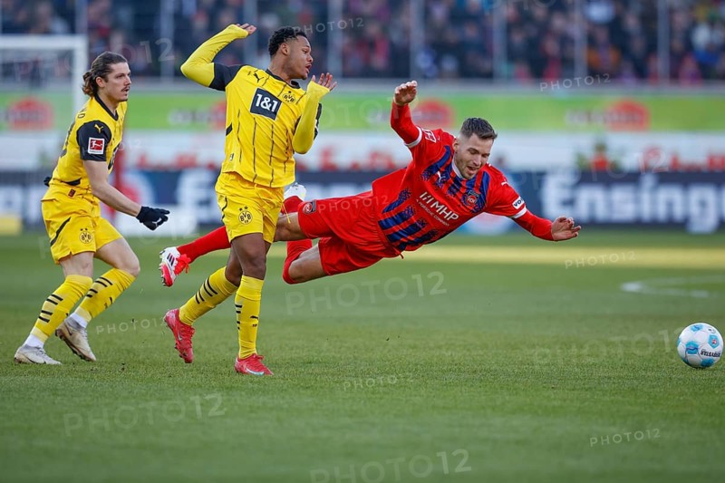 Germany: Soccer 1st Bundesliga, Matchday 20 - 1. FC Heidenheim vs. Borussia Dortmund - Voith-Arena Heidenheim: Marvin PIERINGER 1. FC Heidenheim right on the ball is fouled by Julien DURANVILLE Borussia Dortmund, Marvin PIERINGER 1. FC Heidenheim is literally in the air, left outside Marcel SABITZER Borussia Dortmund watches the action