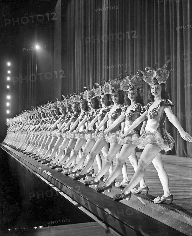 Ballet girls in New York. A long line of dancing girls on stage at Radio City Music Hall in New York are moving together synchronized to the music. 1940s