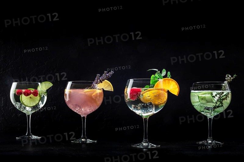 Fancy cocktails with fresh fruit. Gin and tonic drinks with ice at a party, on a black background, with copy space, Food photography, Food photography