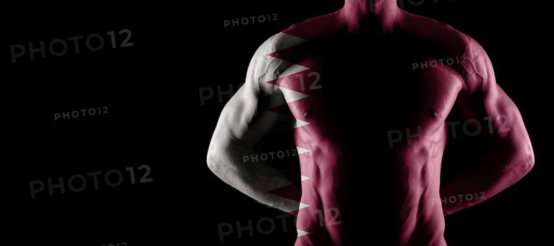 Qatar flag on muscled male torso with abs, black background