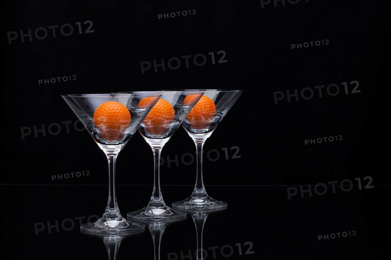 Three glasses of champagne with golf balls
