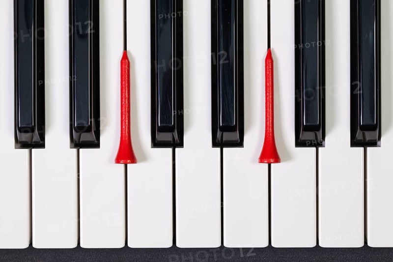 Virtuosic game - Piano keyboard and different golf balls and wooden tees