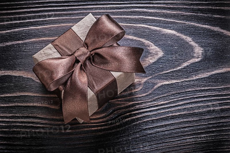 Wrapped gift box on wooden board holidays concept