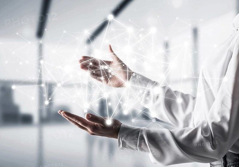 Business woman in shirt keeping white social media network structure in hands with office view on background. Mixed media