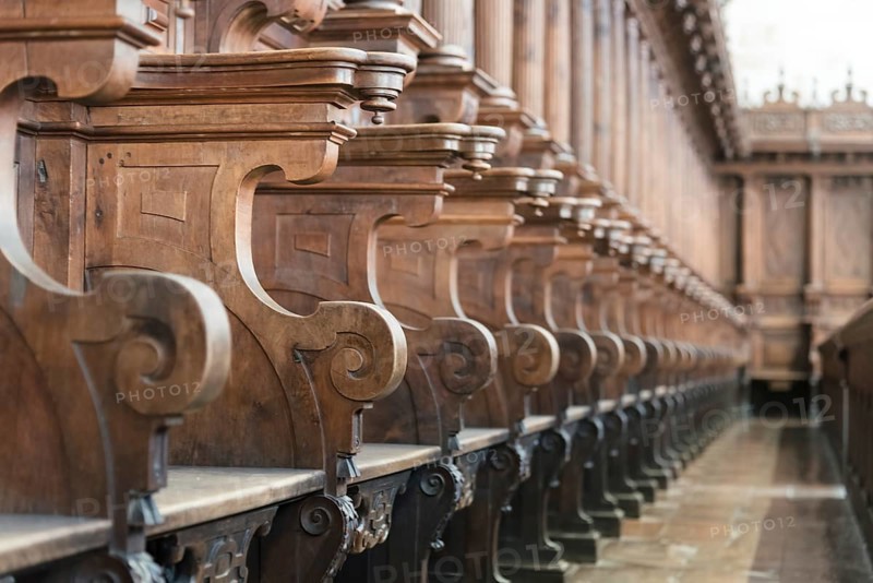 Cathedral choir stalls made of wood. Row of wooden choir stalls