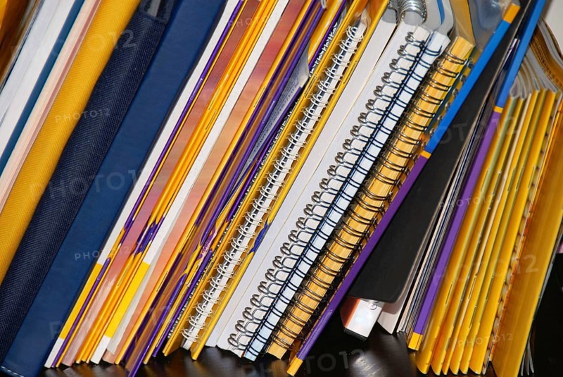 Various notebooks and books on shelf background