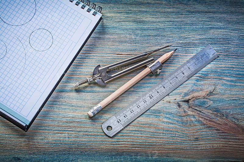 Checked copybook ruler divider pencil on vintage wood board