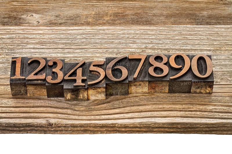 Number abstract in vintage letterpress wood type against grained wooden plank