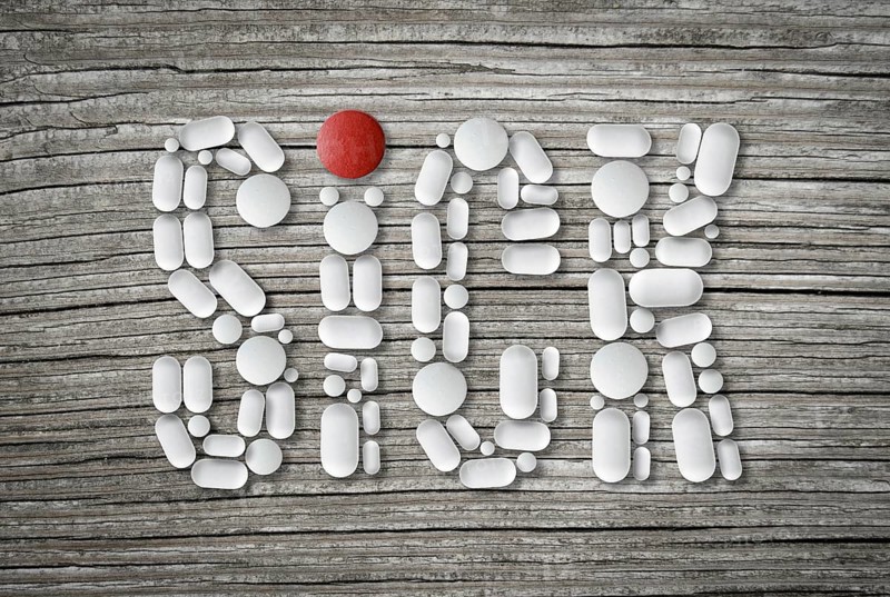 Conceptual Health Image Of Pills On A Wooden Table Spelling The Word Sick