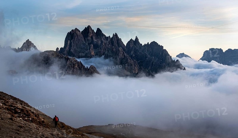 Unrecognised man trekking late in the evening at the hikking path of the picturesque Dolomites at Tre Cime area in South Tyrol in Italy