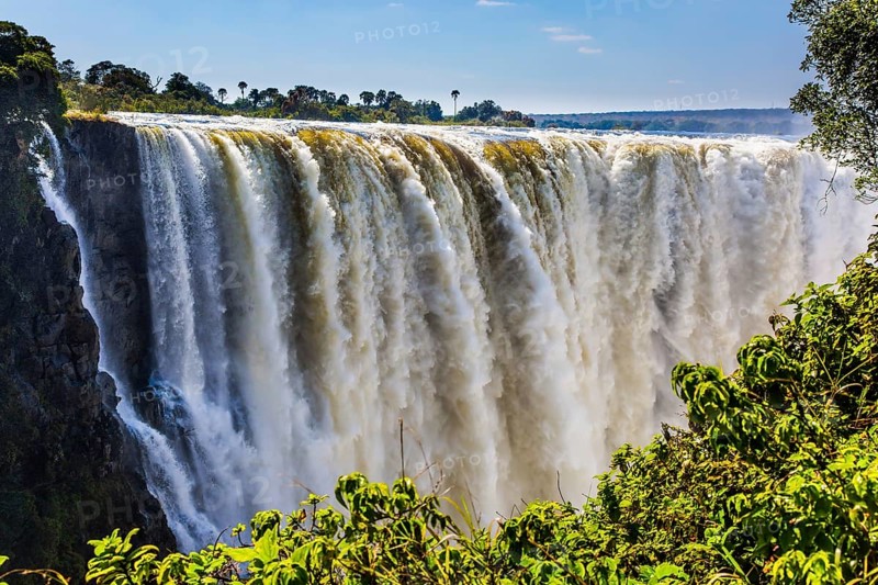 Journey after the wet season. Grand and deep Victoria Falls after the rainy season. Victoria National Park, the Zambezi River. Concept of extreme and photo tourism