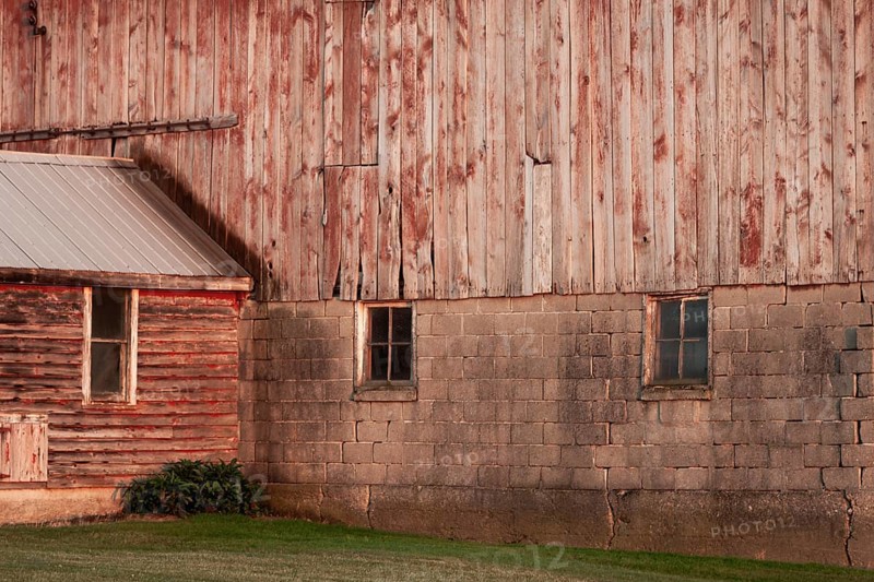 A rustic barn wall with wooden planks and brick foundation in rural setting in Ontario, Canada, North America