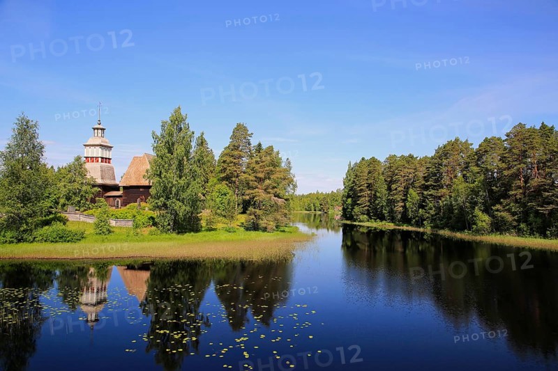 Finnish blue lake and sky landscape with UNESCO World Heritage site, old wooden church of Petajavesi, Finland in summer. The church was built 1763-65