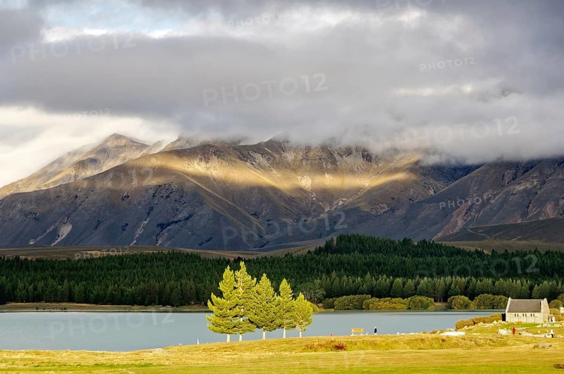 Sun breaking through the clouds over Lake Tekapo and the Church of the Good Sheppard on the South Island of New Zealand