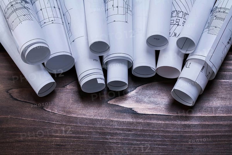 Pile of blueprint rolls on pine wooden vintage board maintenance concept