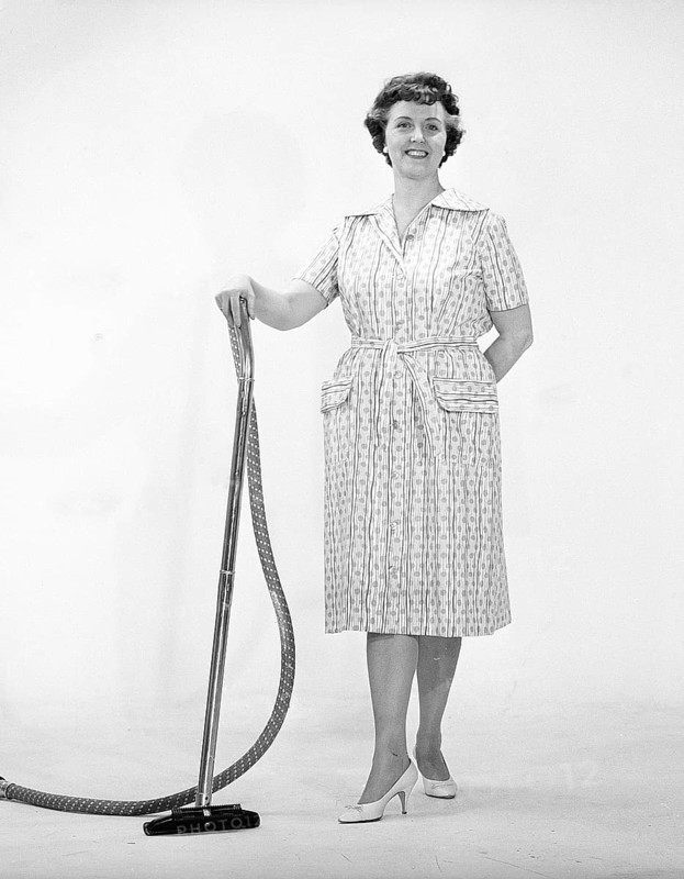 Cleaning day in the 1960s. A woman is standing holding a vacuum cleaner, looking happy. Sweden 1960s Kristoffersson ref CN109-10