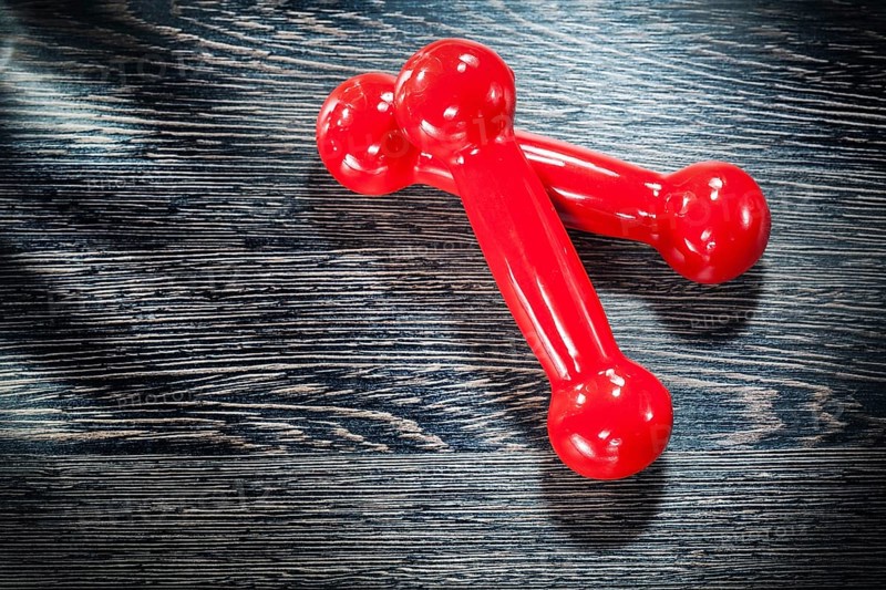 Red dumbbell weights on vintage wooden board