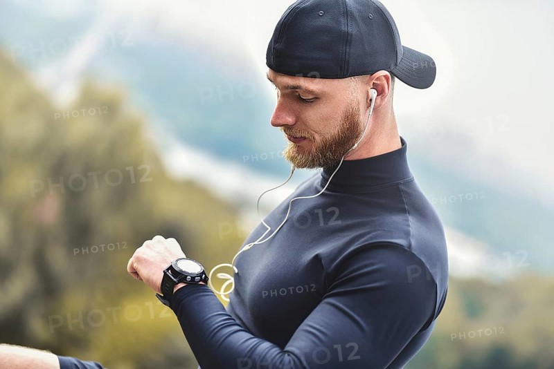 Close-up Shot Bearded Sportive Man After Workout Session Checks Fitness Results. Adult Guy Wearing Sport Tracker Wristband