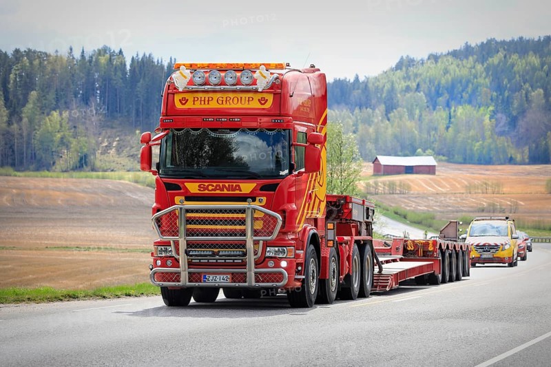 Scania truck of PHP Group in front of gooseneck trailer returns from delivering oversize load, followed by escort vehicle. Salo, Finland. May 15, 2021