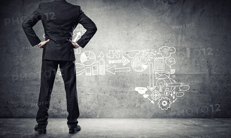 Back view of confident businessman in empty concrete room