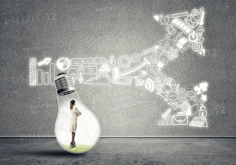 Businesswoman inside of light bulb in empty concrete room