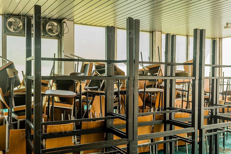 Goesan, South Korea. May 29, 2020: Chairs and tables stacked haphazardly in sunlit room of bankrupt resort