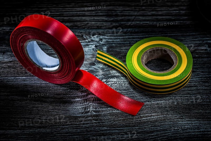 Rolled insulation tapes on vintage wooden board