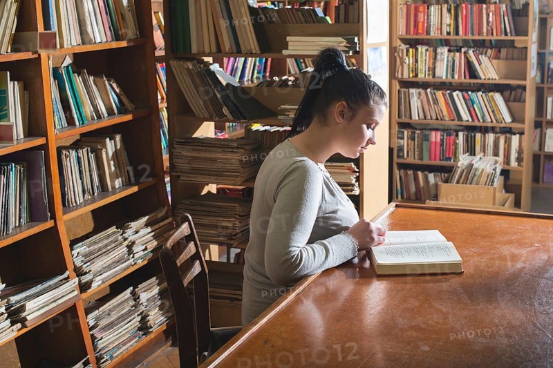 Student girl in a library. Looking at book
