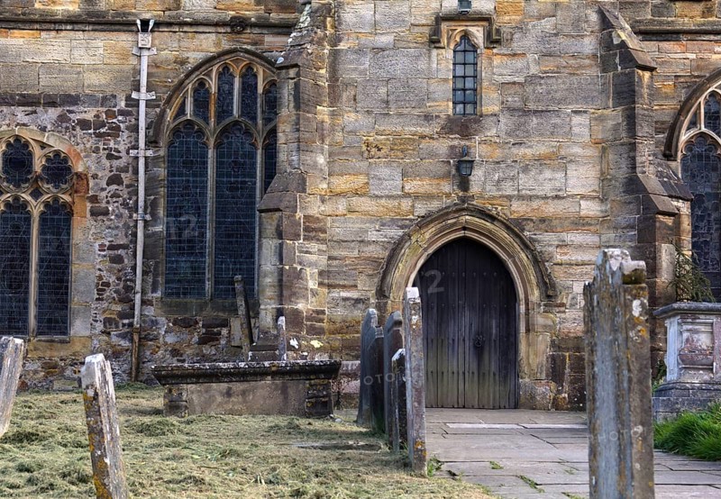 The oldest part of the St Laurence church in HawkhurstKent the lower part of the tower dates from the 12th Century. Following the destruction during the Border Wars came 14th Century rebuilding, and restoration in the 17th, 18th and 19th Centuries. Work from all these periods can be seen. Here we see the entrance with tombstones in the front
